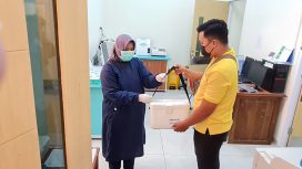 Petugas RSUD Campurdarat Tulungagung menyerahkan obat ke driver Maxim untuk diantarkan ke rumah pasien (Istimewa)