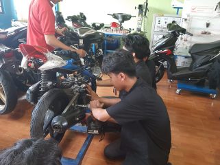 Siswa sedang belajar melakukan perbaikan sepeda motor